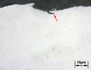 Figure 3 - Metallography of bar surface. Material SAE 6150. Arrow indicates small overlap in a peened depression surface. Magn.: 500x. Courtesy: Testmat.