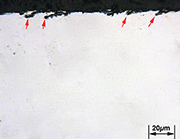 Figure 4 - Metallography of spring surface. Material SAE 9254. Arrow indicates surface crack of 8