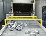 Outlet of an AGTOS-Wire mesh conveyor shot blast machine for aluminum work pieces, Type BS