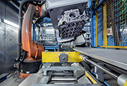 A robot arm picks up a workpiece for blasting in Wheelabrator’s IDS machine