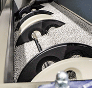 The gantry crane automatically lowers the mounting frame with raw workpieces onto special guide rails in the tub. This allows the frame to rotate freely in the processing media. Upon completion of the finishing cycle, the frame with the finished workpieces can be fully automatically removed from the tub