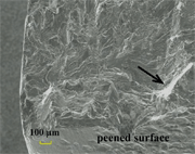 Figure 2: SEM fractograph for 2024-T351 Aluminum Alloy peened to particular conditions showing initiation site (indicated by the square frame) at stress level of smax= 300 MPa; R=0.1 and constant amplitude sinusoidal loading with a frequency of 
20-25 Hz at ambient temperature. This picture illustrates a subsurface crack initiation indicated by the arrow, which is located at 150-200